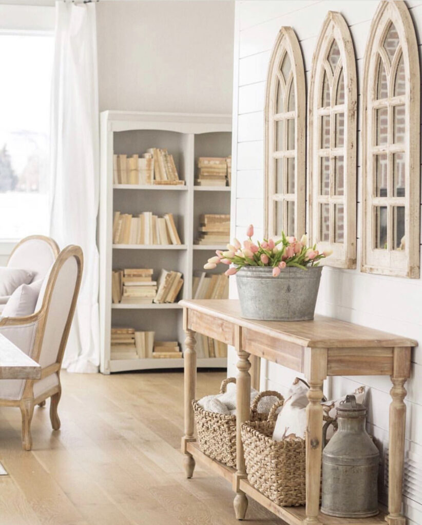 A big galvanized bucket filled with pink tulips sit on a console table in a dining room. It's a gorgeous farmhouse Spring decor idea.