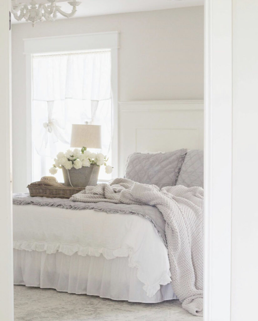 Floral Arrangement in a bucket on a bed with white bedspread - A beautiful, cheery idea for early Spring decor.