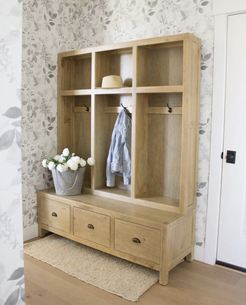 a mudroom with a wooden locker system with a bucket of white flowers sitting on the bench for a cheery early spring decorating idea