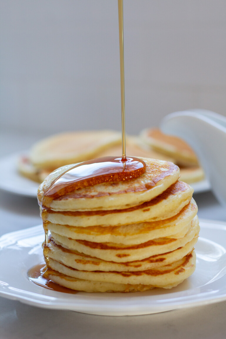 Pancake with syrup being drizzled on top.